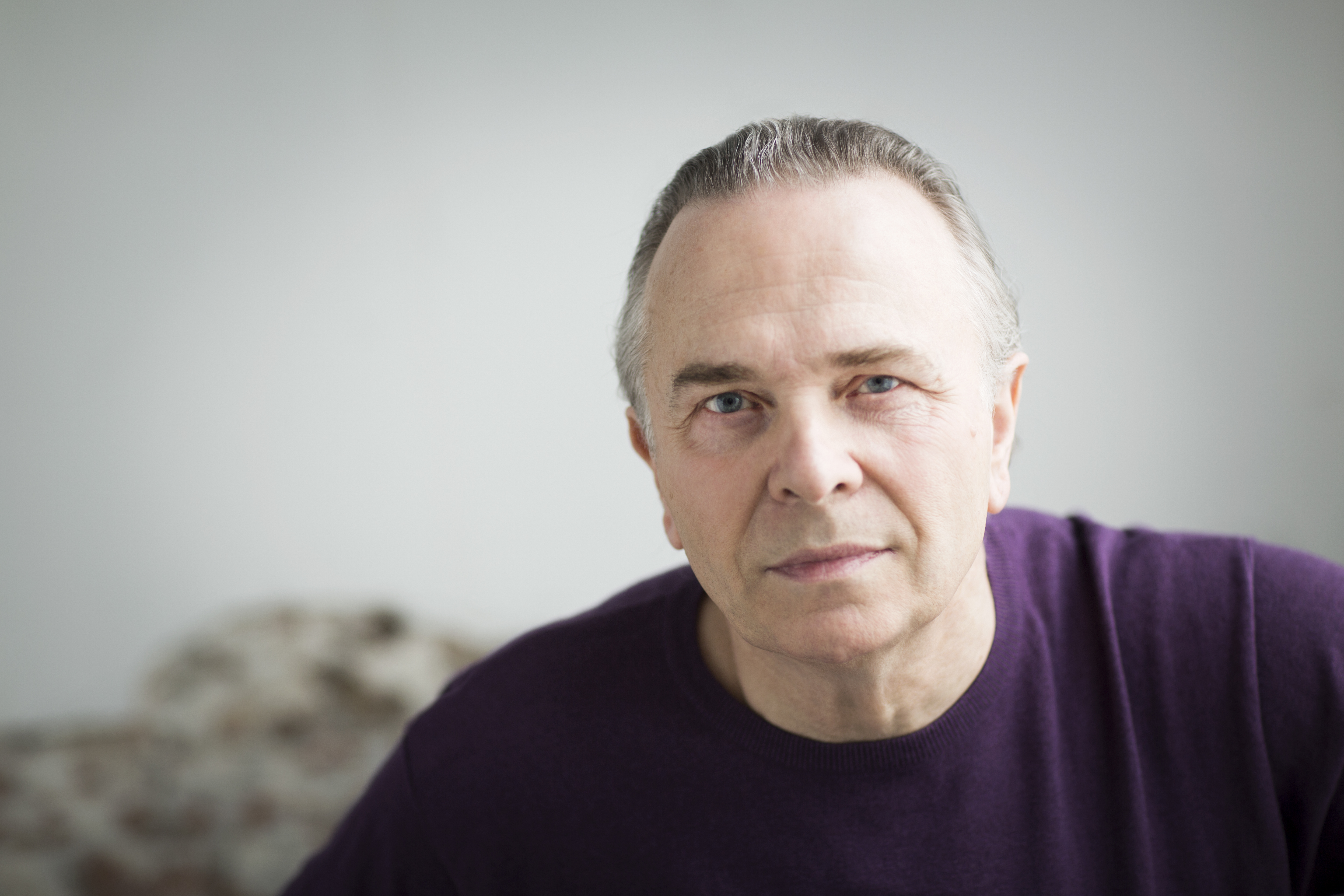 Image of conductor Sir Mark Elder, wearing a purple jumper